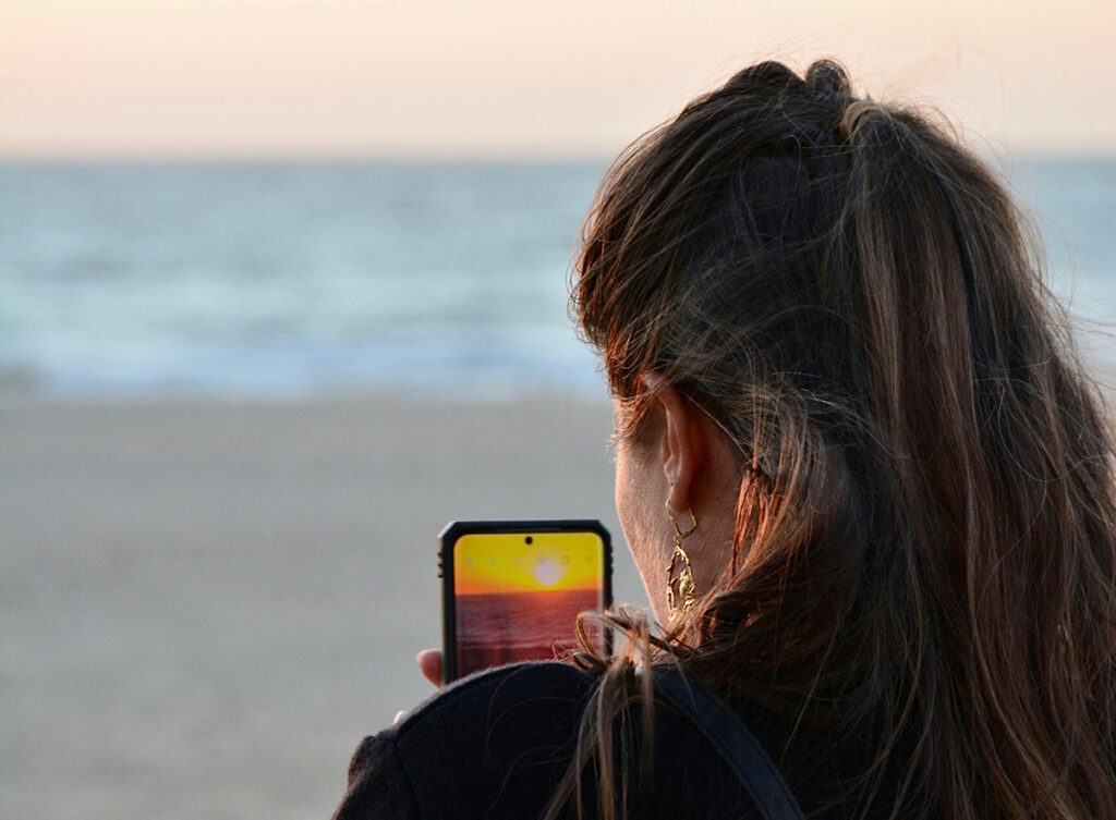 Illustration : julie qui prend une photo sur son smartphone